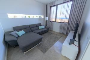 a living room with a couch and a television at Villa Marina, Sol y Sal in Las Palmas de Gran Canaria