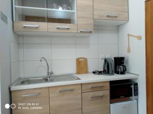 a kitchen with wooden cabinets and a sink at Paleokastritsa Studios - Sun's Gift Spiros in Paleokastritsa
