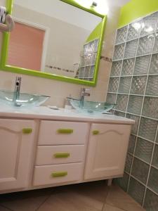 La salle de bains est pourvue de 2 lavabos et d'un miroir. dans l'établissement Residence Clementine villa Douceur, à Grand-Bourg