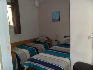 een groep van drie bedden in een kamer bij maisonnette entre forêt et occéan in Vendays-Montalivet