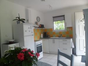 een keuken met een witte koelkast en een fornuis bij maisonnette entre forêt et occéan in Vendays-Montalivet