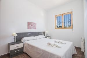 1 dormitorio con 1 cama con 2 zapatillas en Villa Fanadix - Plusholidays, en Benissa