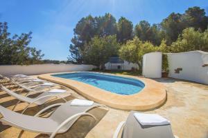 a swimming pool with lounge chairs next to a wall at Villa Fanadix - Plusholidays in Benissa