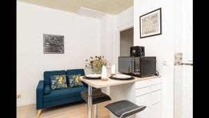 梅斯的住宿－Le Petit Marcel，客厅配有桌子和蓝色沙发