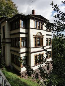 a large white house with windows on a hill at Pension Tannenrausch in Friedrichroda