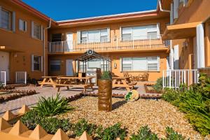 a patio with a table and benches in front of a building at Riptide Oceanfront Hotel in Hollywood