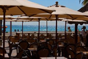 ハリウッドにあるRiptide Oceanfront Hotelのビーチのパラソル付きテーブルと椅子