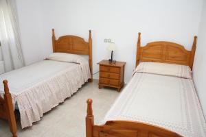 a bedroom with two beds and a table with a lamp at Adosado Peñisol Inmomart in Peniscola +11 photos