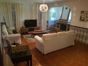 un salon avec deux canapés blancs et une télévision dans l'établissement Quinta da Paz, à Borba