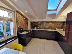 a kitchen with black cabinets and a large window at Sopot Przy Plaży in Sopot