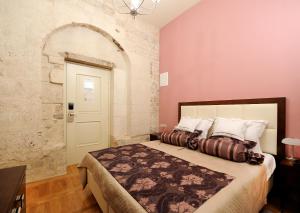 sypialnia z łóżkiem i białymi drzwiami w obiekcie Palace Augubio w Splicie