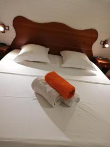 a bed with two towels and two pillows on it at Résidence Clémentine Villa Passion in Grand-Bourg