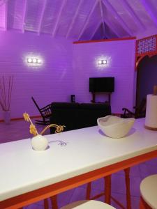 una habitación púrpura con una mesa con un tazón. en Résidence Clémentine Villa Passion en Grand-Bourg