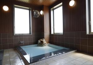a large bathroom with a hot tub with two windows at Hotel Ocean Iwasawa / Vacation STAY 33555 in Kido
