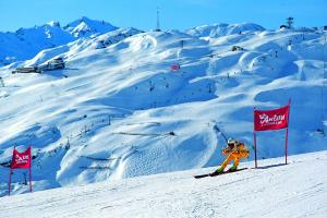 osoba jeżdżąca na nartach po pokrytym śniegiem stoku z czerwonymi flagami w obiekcie Haus Saumspitz w mieście Sankt Anton am Arlberg