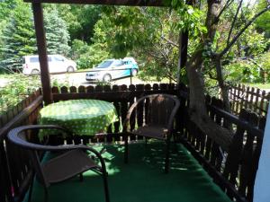 een tafel en stoelen op een veranda met een boom bij Große rustikale Ferienwohnung am Stadtrand von Röbel an der Müritz mit Balkon in Röbel