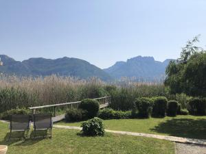 two chairs in a garden with mountains in the background at Angel Services - LA MAISON DE LA PLAGE in Sévrier