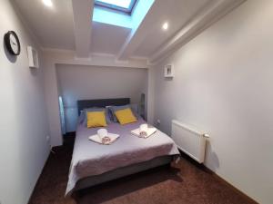 a bedroom with a bed with yellow pillows and a window at Sopot Przy Plaży in Sopot
