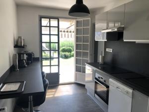 a kitchen with a black counter top and a window at Angel Services - LA MAISON DE LA PLAGE in Sévrier