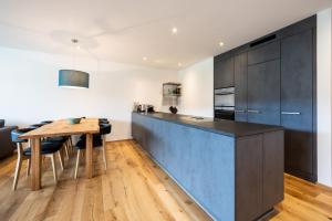 a kitchen with a wooden table and a blue counter top at Casa Miraselva in Flims