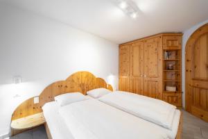 um quarto com uma cama de madeira e armários de madeira em LAAX Homes - Runca 752 em Flims