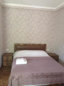 1 dormitorio con 1 cama con colcha púrpura en Resort Hotel surami en Surami