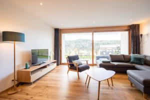 a living room with a couch and a tv at Casa Miraselva in Flims