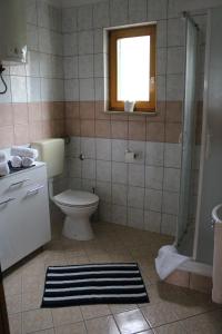 a bathroom with a toilet and a window at Apartment Lilly in Nerezine +14 photos