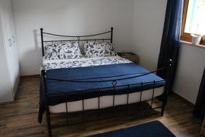 1 dormitorio con 1 cama con almohadas azules y blancas en Apartment Lilly en Nerezine