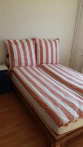 a bed with a red and white striped comforter at Natur-Freude-16 in Kotzen