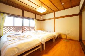 a bedroom with two beds and a large window at Takayama - House / Vacation STAY 34378 in Takayama