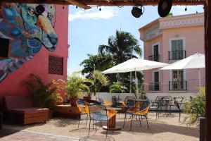 an outdoor patio with chairs and tables and umbrellas at Wabi Hostel in Playa del Carmen