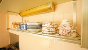 a shelf with plates and bowls on it in a kitchen at Takayama - Apartment / Vacation STAY 34379 in Takayama