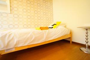1 dormitorio con 1 cama con sábanas blancas y mesa en Takayama - Apartment / Vacation STAY 34381 en Takayama