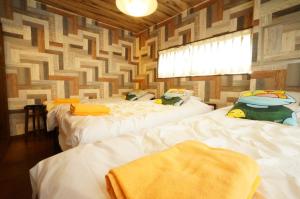 two beds in a room with a wall at Takayama - Apartment / Vacation STAY 34382 in Takayama