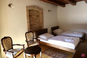 a room with two beds and two chairs and a table at Rábagyarmati Apartman II in Rábagyarmat