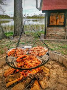 a grill with some food on top of a fire at domek campingowy in Brachlewo