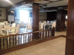 a dining room with white tables and white chairs at Hostal El Arco in Almazán