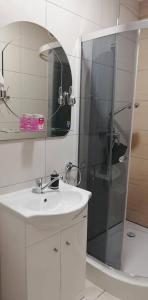 a bathroom with a sink and a shower with a mirror at domek campingowy in Brachlewo +24 photos