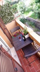 een balkon met 2 stoelen en een tafel met bloemen bij Aldo's house in La Spezia