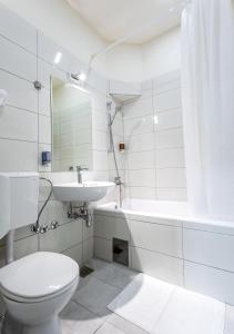 un bagno bianco con un water e un lavandino di Booking En Suite a Belgrado
