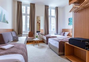 una camera d'albergo con due letti e un divano di Booking En Suite a Belgrado