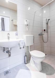 un bagno bianco con un water e un lavandino di Booking En Suite a Belgrado