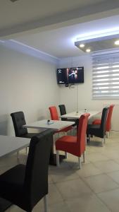 a dining room with tables and chairs and a tv at Airport view Apartment in Belgrade