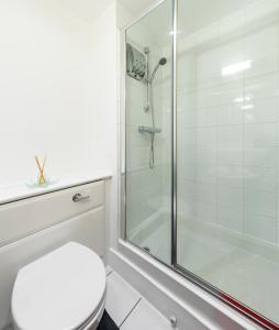 y baño blanco con ducha y aseo. en COSY RIVERVIEW-LONDON EXCEL CENTRE-O2 ARENA en Londres