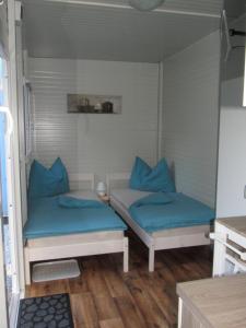 - 2 lits dans une petite chambre avec des oreillers bleus dans l'établissement Ferienwohnungen Köckhausen Nähe Red Bull Ring, à Rattenberg