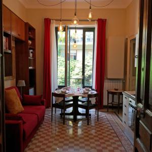 サレルノにあるCasa Vacanze Archi Medievaliのリビングルーム(テーブル、赤いソファ付)