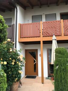 a patio with a deck and an umbrella on a house at Ferienappartement Souterrain in Volkertshausen