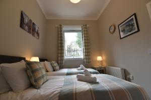 un animal de peluche sentado en una cama en un dormitorio en Pleasance Apartment Ground Floor Main Door Access, en Edimburgo