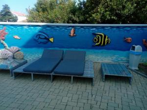 a wall with two benches in front of a aquarium at Villa Ani in Novalja